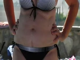 A girl with a pretty figure jumps on her friend